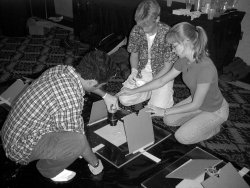 SALTA students gluing photomultiplier tubes to scintillator panels at the Snowmass workshop.